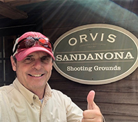 Joel standing next to the Sandanona Shooting Grounds sign