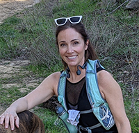 Jill outside with her backpack and dog