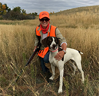 Marka Hansen posing with her dog in a field