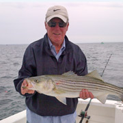 Michael holding a fish in a boat on open water