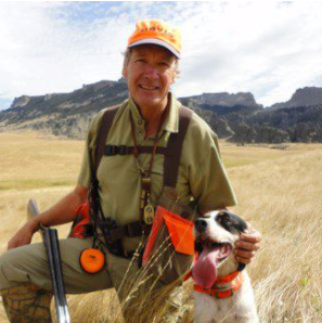 Dave Perkins in a field with a dog and shotgun